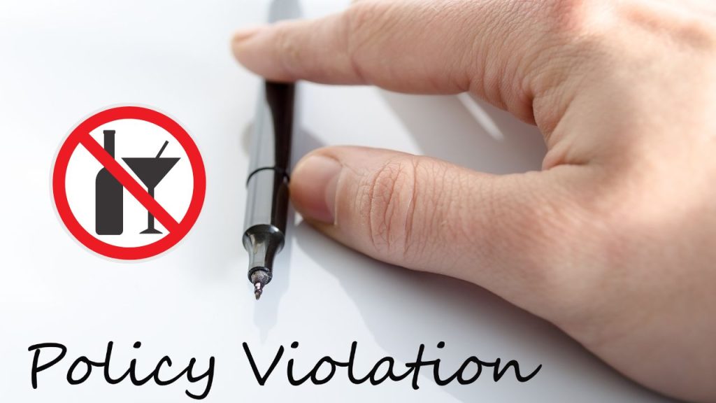 faa policy violations: up close shot of hand touching a pen with writing that says policy violation 