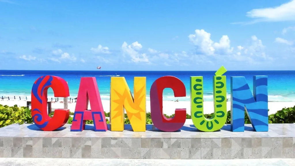 beach scene with lifesize letters spelling out Cancun
