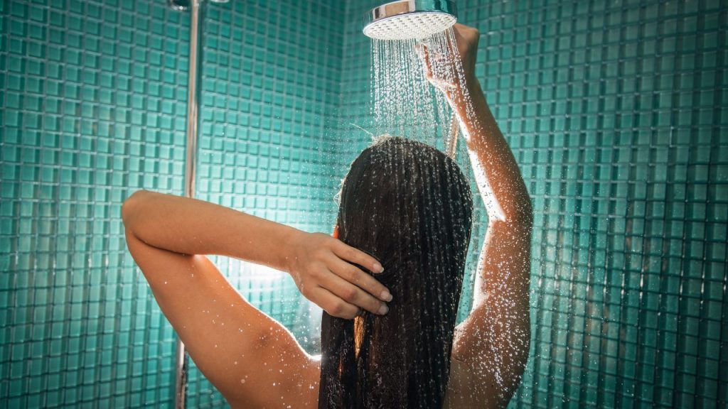 lady standing in shower with water running over body