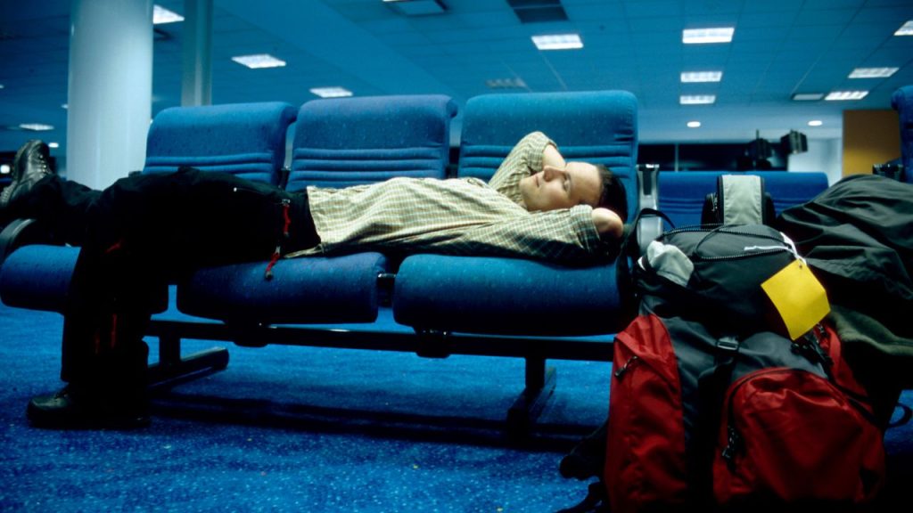 man sleeping at the airport at night