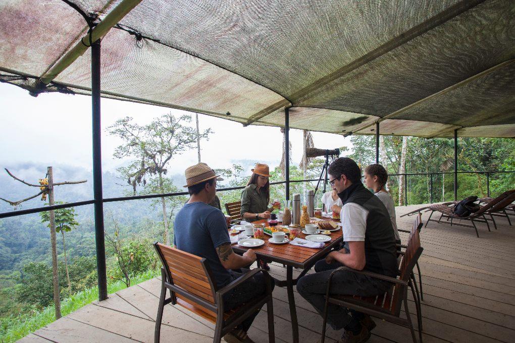 People eating breakfast on deck overlooking the rain forest.