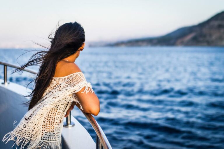 Lady looks out at sea posing for picture on cruise ship.