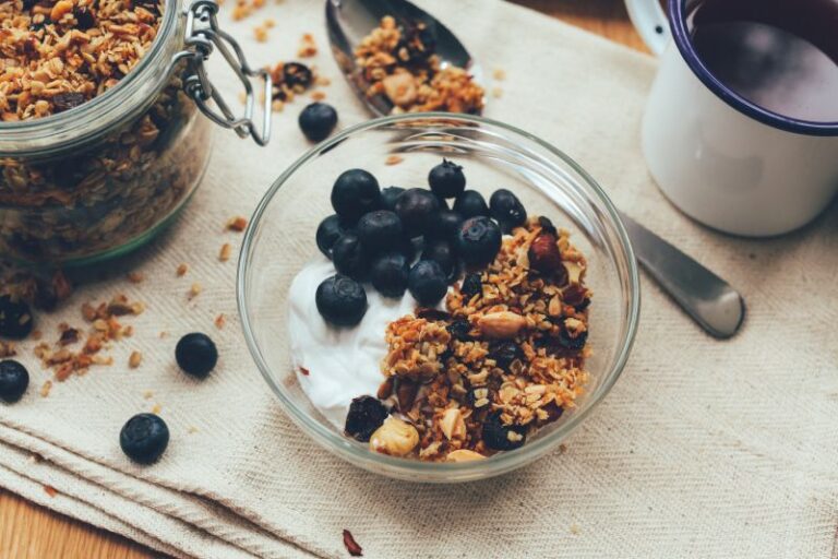 Greek yogurt, granola, and blueberries in a bowl, a great pre- or post-workout meal.