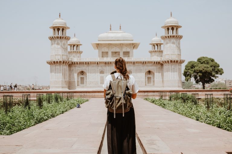 Solo traveler looks at Taj Mahal in Agra, India.
