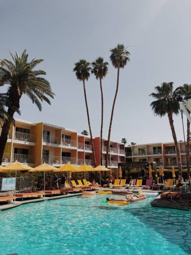 Stylish hotel with palm trees and a courtyard pool.
