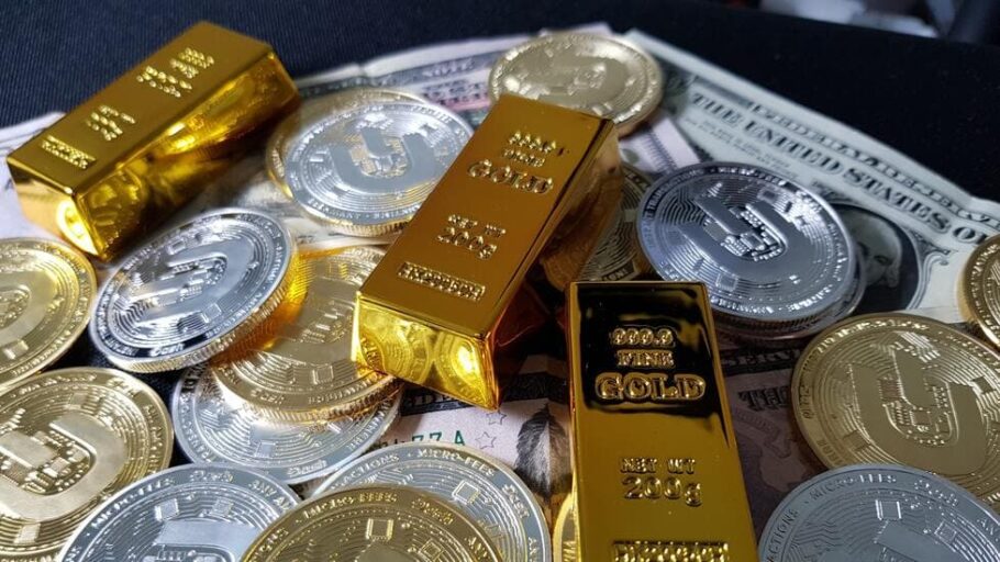 Gold bars and silver coins scattered on a tray. 