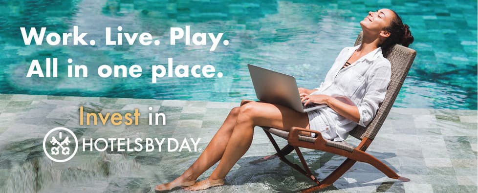 Woman sits on beach chair near pool while working on laptop. 